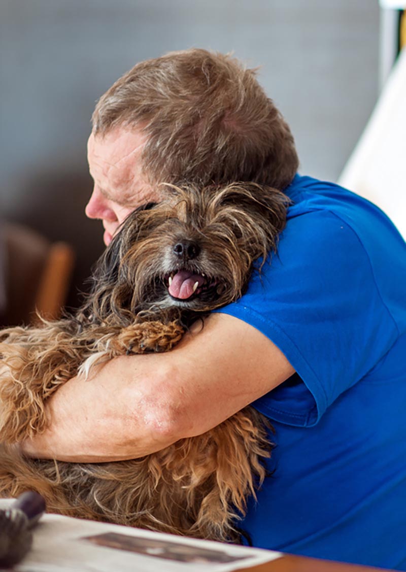 elderly man holding shaggy dog